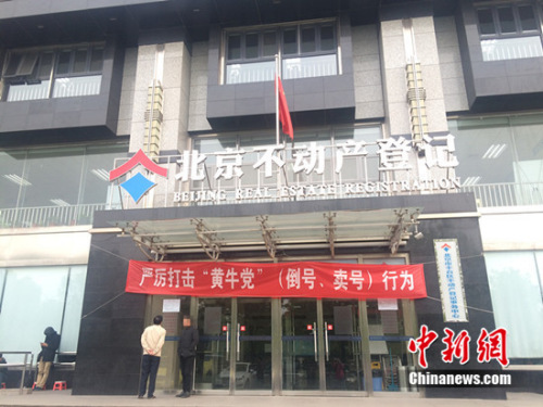 丰台区不动产登记事务中心大楼入口处的横幅上写着“严厉打击‘黄牛党’(倒号、卖号)行为”几个字。<a target='_blank' href='http://www.chinanews.com/' >中新网</a> 邱宇 摄