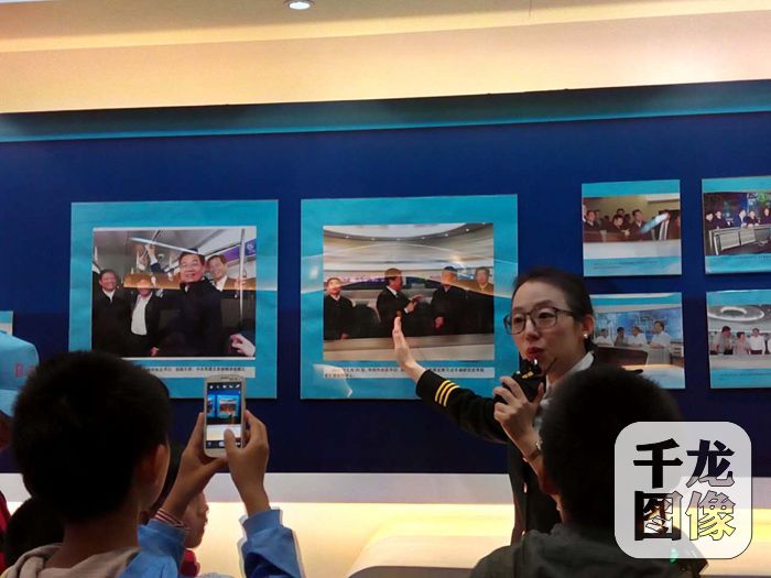 讲解员给参观人员讲解图片。千龙网记者李泽杰摄