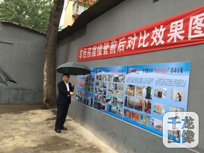 现场负责人介绍小区接管前后效果图。千龙网记者徐鑫鑫摄