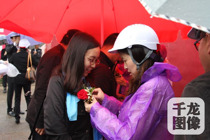 5月14日上午，北京建工集团邀请业主前来参观动力港自住房项目。图为工作人员为签到业主佩戴胸花。北京建工集团供图。