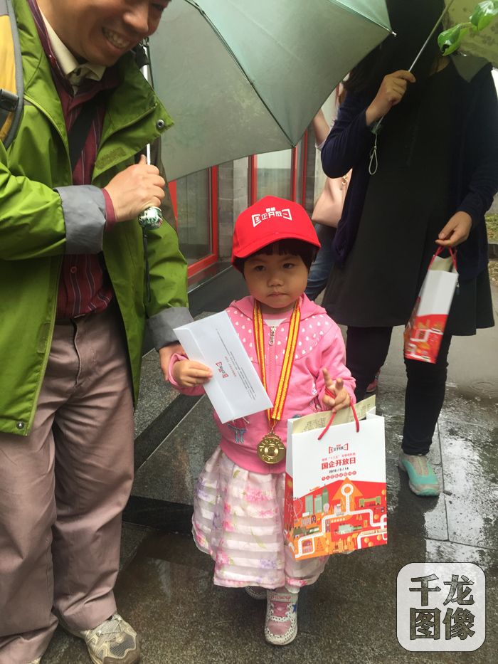 小朋友手提国企开放日宣传袋。千龙网记者王漓鹂摄