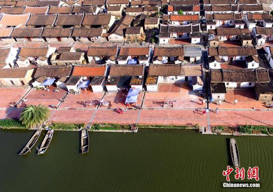 5月底，记者走进位于福建省龙海市东园镇九龙江南溪下游的埭美村，红砖瓦、灰白墙、燕儿尾，典型闽南建筑风格扑面而来。埭美村全村四面环水，被称为“水上古村落”，村内古厝成群，是闽系红砖建筑文化的杰出代表，先后获评福建省历史文化名村和中国历史文化名村。图为空中俯瞰古民居。