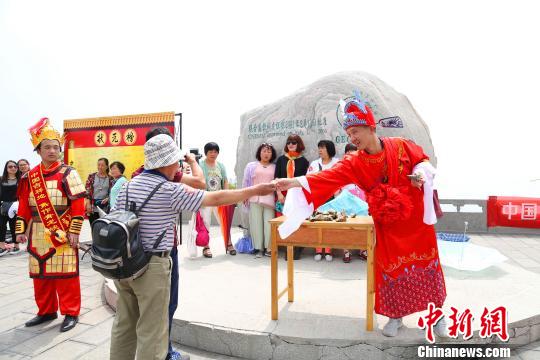 图为“状元郎”为学生与家长游客送吉祥粽子。　周小云　摄