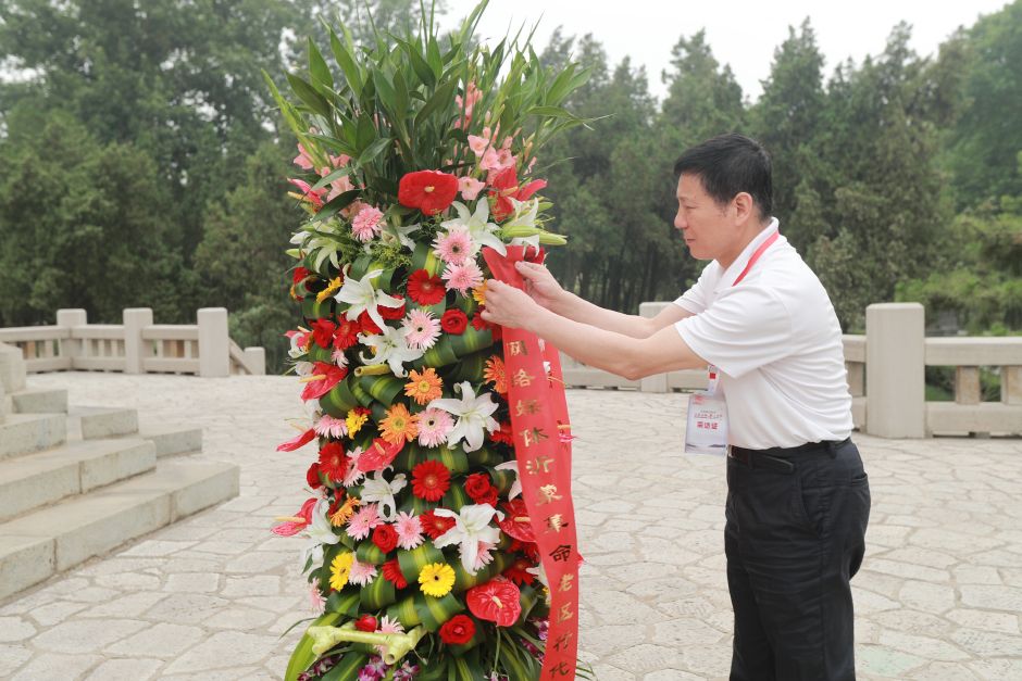 北京市网信办党组书记、主任佟力强精心整理花篮绶带。记者 王长坤 摄