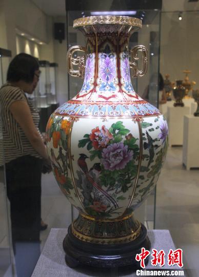 由北京市珐琅厂送展的《吉庆泰和尊》由中国工艺美术大师钟连盛等六位大师联袂创作而成，整件作品为六面开光，分别寓意福寿双全、安居乐业、喜上眉梢、事事如意、月月圆满、合合美美，因造型精美引得观众纷纷驻足。　李妮 摄