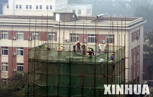 2005年9月11日，工人们正在拆除“烟囱”。新华社记者 李文摄