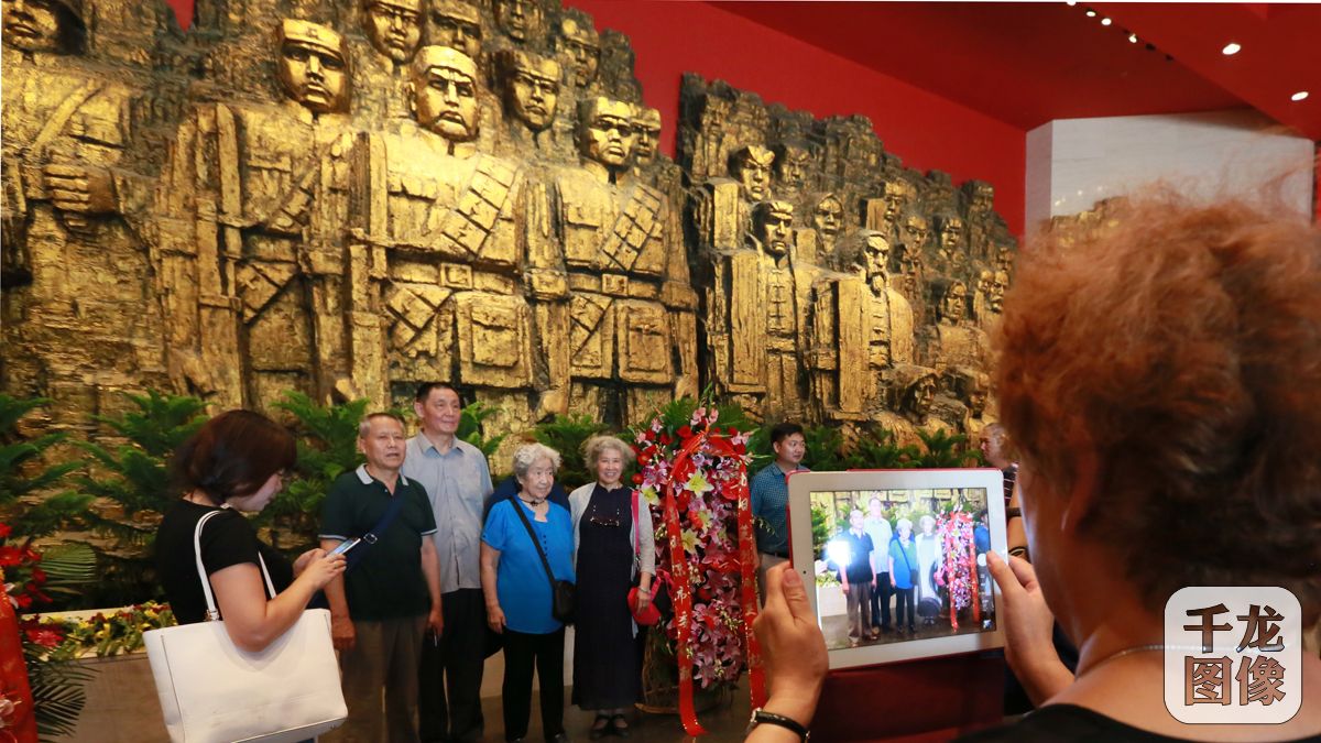 7月7日，全民族抗战爆发79周年纪念活动在中国人民抗日战争纪念馆举行。图为花甲老人在抗战先烈雕塑前合影留念。千龙网记者 张亚亚摄