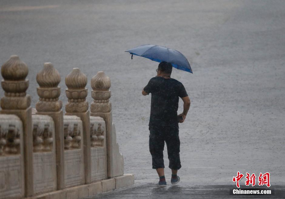 北京遭遇强降雨  游客冒雨游览故宫
