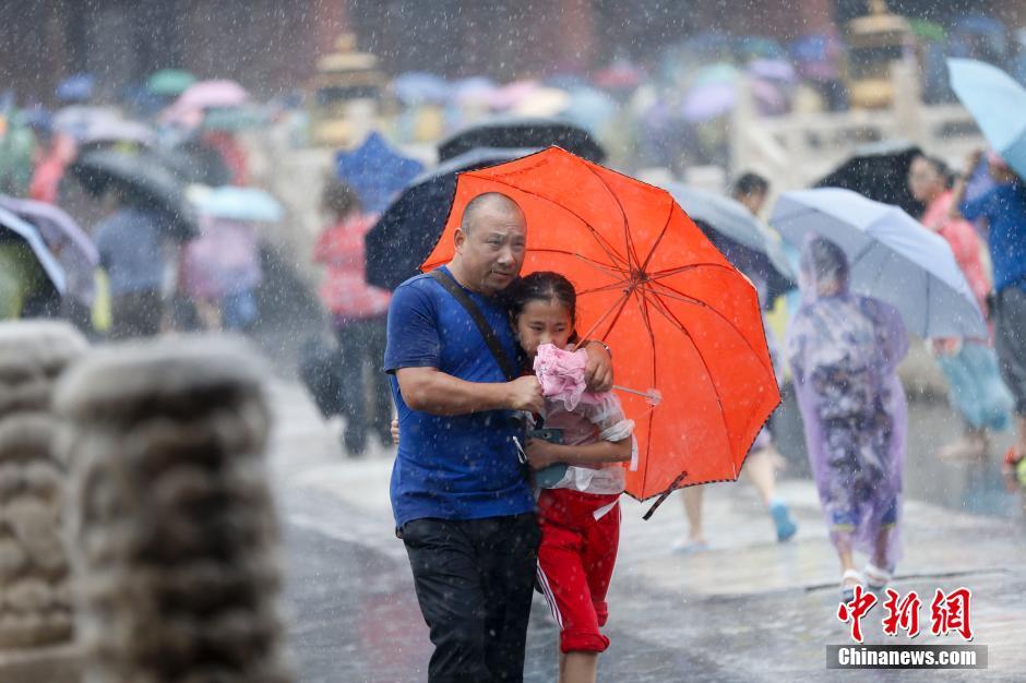 北京遭遇强降雨  游客冒雨游览故宫