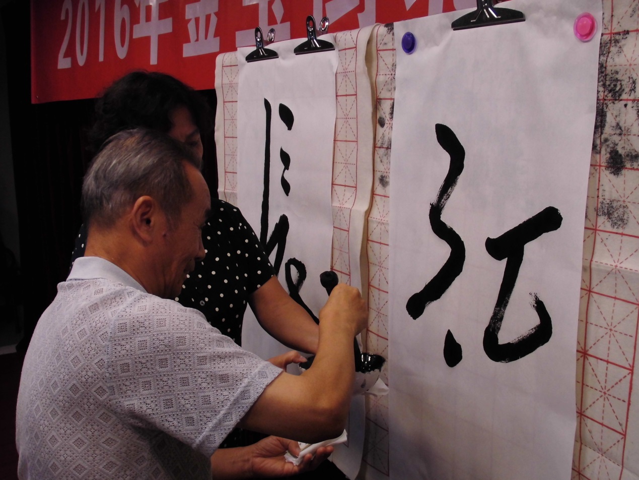 7月25日，金宝街北社区群众文化展演，书法班正在书写“长征”。千龙网记者郑肖云摄