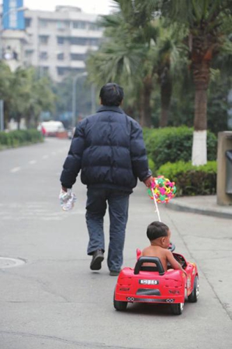 图为垃吉儿和爸爸去广场玩。