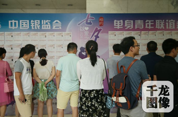 参加国家机关、央企大型单身青年联谊会的青年朋友在活动现场关注嘉宾信息。