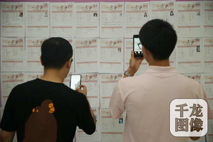 参加国家机关、央企大型单身青年联谊会的男嘉宾用手机记录女嘉宾的信息。