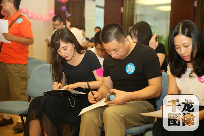 参加国家机关、央企大型单身青年联谊会的男女嘉宾在做游戏。