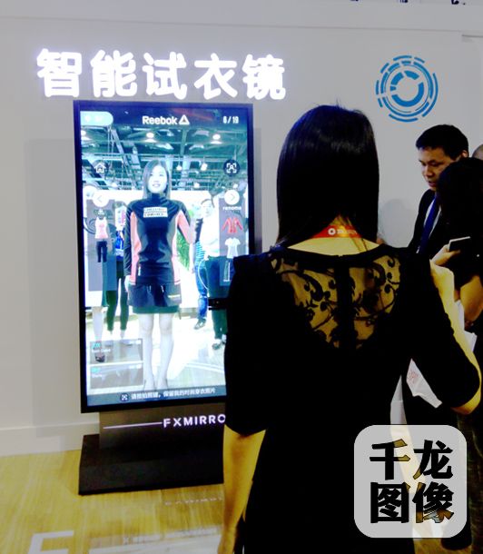 2016’飞凡商业博览会暨第十届万达商业年会现场，智能试衣镜成为观众瞩目的焦点，据产品研究人员介绍，智能试衣镜可免去“脱来换去”的不便，系统根据身材自动匹配衣服，可360度观赏上身效果，并且服装价格一目了然。（实习记者詹婷婷摄）