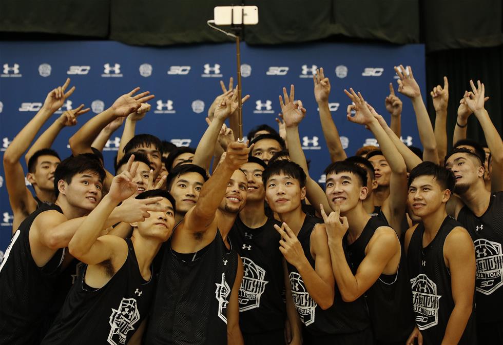 9月3日，库里（中）在华南农业大学篮球馆内与小球员们自拍合影。当日，NBA勇士队球星库里现身广州华南农业大学，开启“传旗亚洲”之旅史蒂芬·库里中国行的第二站。 　　新华社记者吴鲁摄