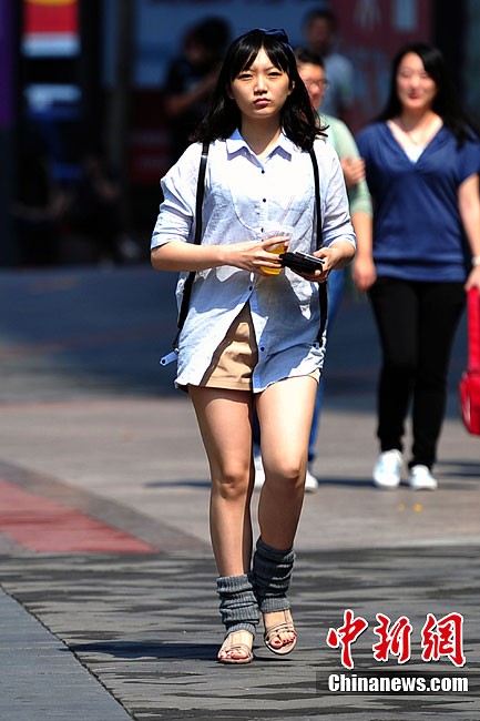 “白露身不露” 北京街头行人“混搭装”出行