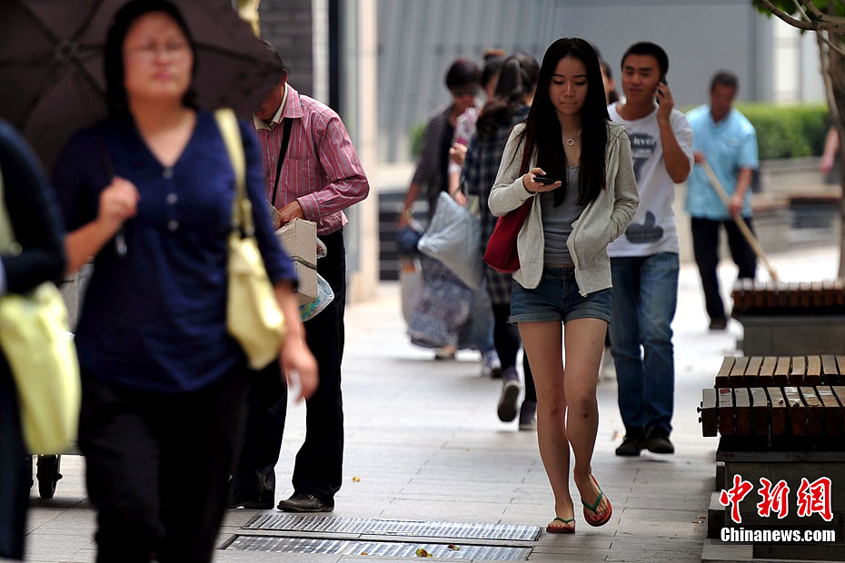 “白露身不露” 北京街头行人“混搭装”出行