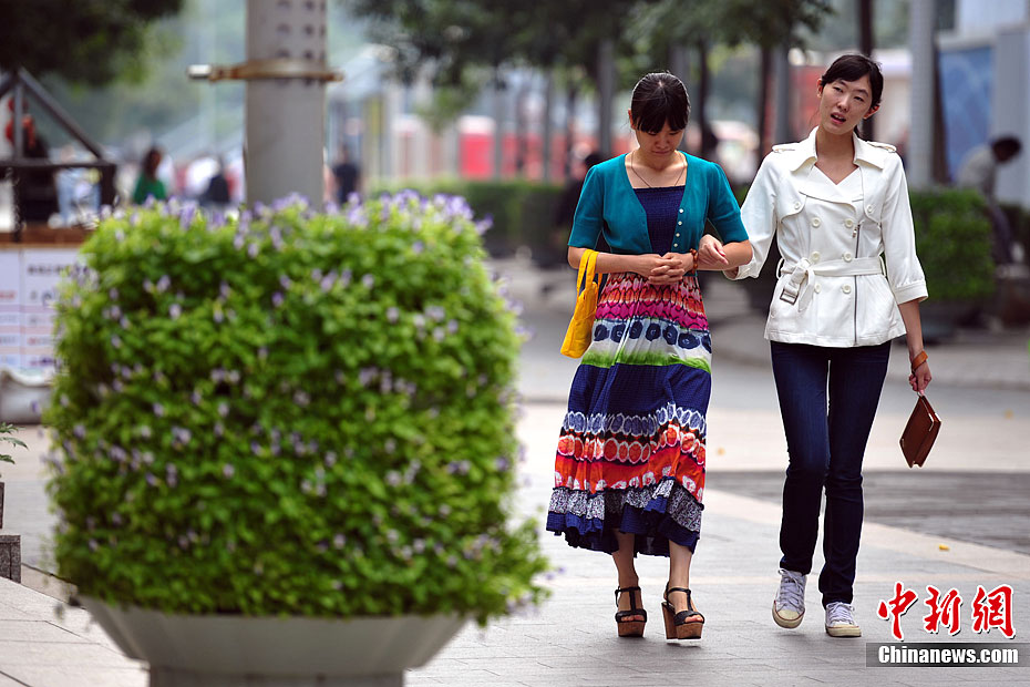 “白露身不露” 北京街头行人“混搭装”出行