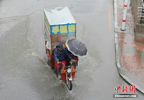 图为市民雨中出行。张瑶 摄
