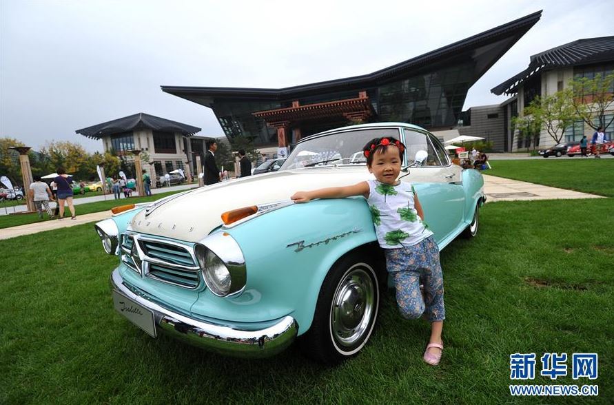 9月17日，小朋友在一辆老爷车旁拍照。中秋佳节之际，2016雁栖岛优雅大展在北京怀柔雁栖湖畔举办，来自全球8个国家18个汽车品牌的50辆珍贵经典车型和现代优雅车型在本次车展上亮相，吸引市民游客前来观看。新华社记者李任滋摄