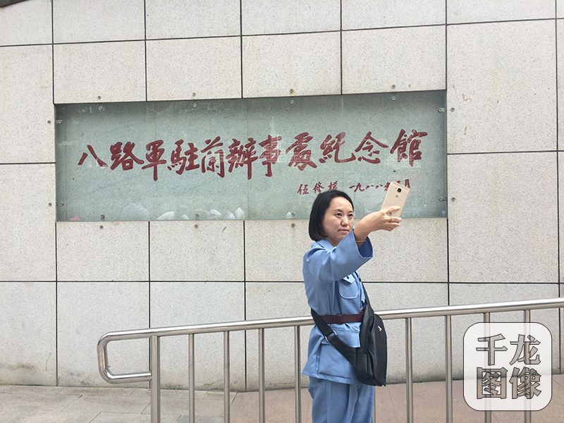 一位身着戎装的采访团成员在纪念馆前自拍留念。千龙网记者 马文娟 摄
