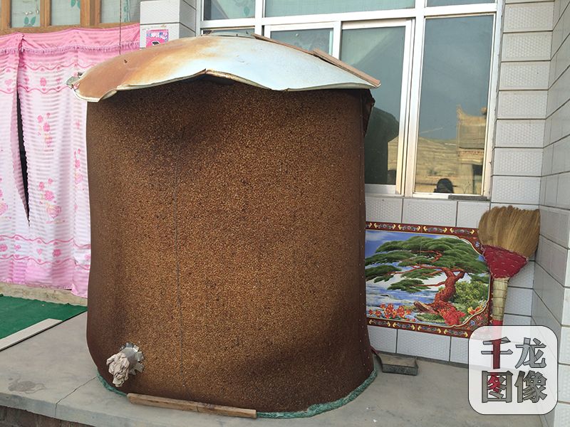 院子里堆放着一座玉米仓，这是未来四五个月，家里牛羊的口粮。千龙网记者 马文娟 摄