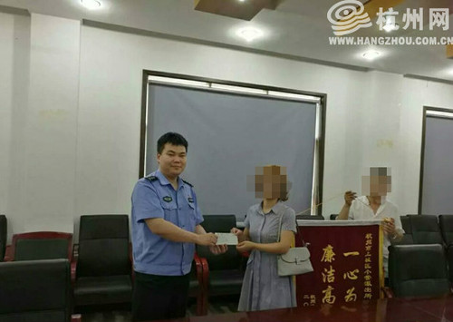 会计刘女士从民警手中接过48万元的支票。