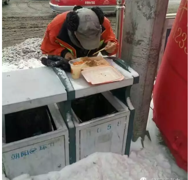 马路旁,堆满积雪的垃圾箱上摆放着一个快餐饭盒,里面的饭菜已经少了一半,一名环卫工人俯下身子正大口大口地吃饭,天空中的片片雪花不断飘落在他的衣服和围巾上,饭盒旁摆着一双沾满了积雪的手套……近日,这样一张照片在辽宁省朝阳市市民的手机中盛传,环卫工人的艰辛感动了许多人,甚至有人落泪。 照片中的人叫李贺军,53岁,他之所以没有像其他环卫工人一样找个暖和的地方吃饭,是因为“去屋里给人家地弄埋汰了”。身为环卫工人,整天跟垃圾打交道,他知道干净的重要性。 他把盒饭放