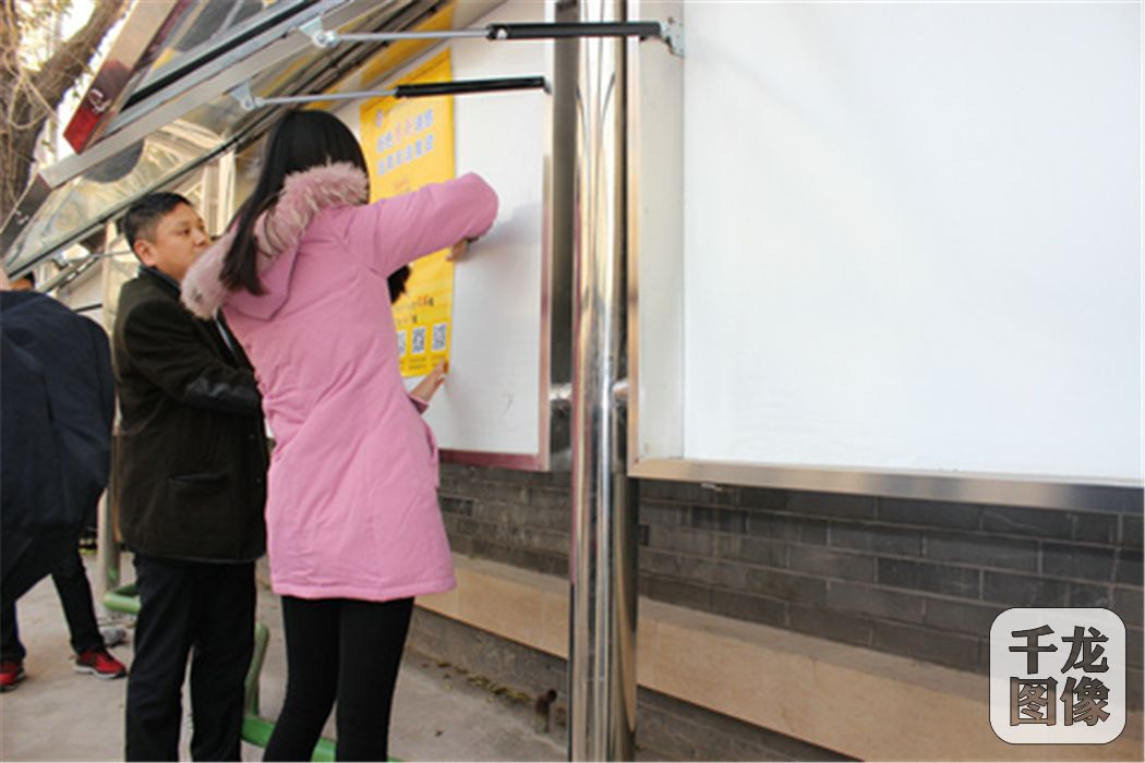 其他人员一起张贴海报