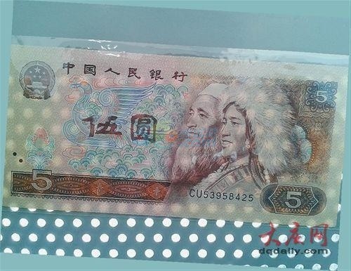 这张纸币大写的伍字缺了一角，露出凤凰的翅膀。