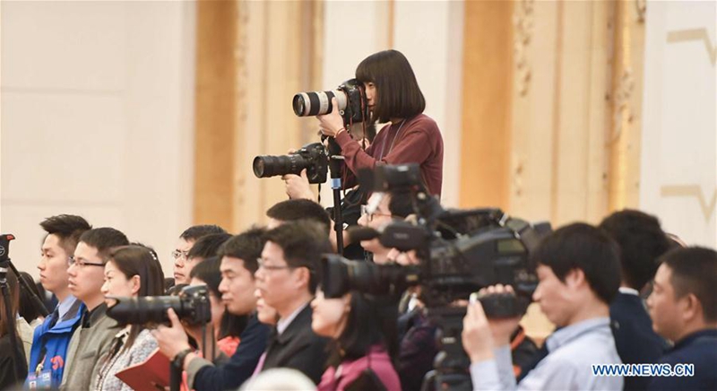 A female photographer works during a panel discussion of deputies to the 12th National People's Congress (NPC) from Jiangsu Province at the annual session of the NPC in Beijing, March 7, 2017. The International Women's Day falls on March 8, during the ongoing sessions of China's National People's Congress (NPC) and the Chinese People's Political Consultative Conference (CPPCC). (Xinhua/Chen Yehua)