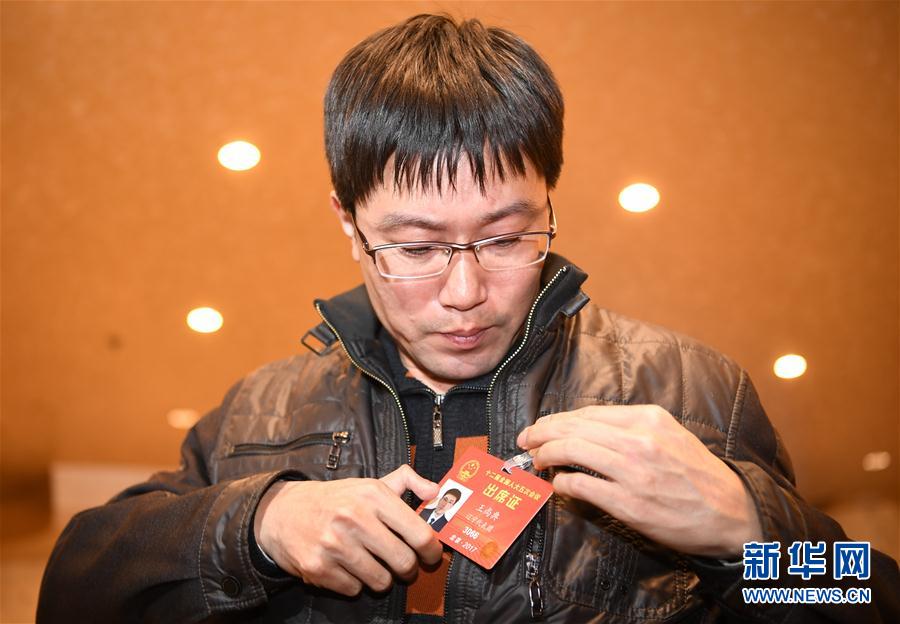 　　全国人大代表王尚典是中国石油天然气集团公司锦西石化分公司机械厂金工车间的一名车工。2005年，王尚典的右手拇指在一次作业意外中粉碎性断裂，用脚趾移植代替拇指后，他重新回到车床前，继续努力工作，逐渐成长为一名车工高级技师，并在2012年第四届全国职工职业技能大赛中勇夺车工冠军。作为一名来自生产一线的人大代表，王尚典特别关注一线技术员工的培养、选拔和激励机制，他说：“质量之魂，存于匠心，这八个字就是我们努力的方向和目标。”    这是3月2日，王尚典抵达驻地后整理证件。 新华社记者 吴晓凌 摄