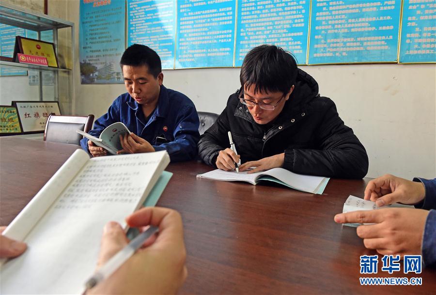 这是2月22日，王尚典（右）在中国石油天然气集团公司锦西石化分公司向工友征求对技术工人培养机制的意见。 新华社记者 杨青 摄