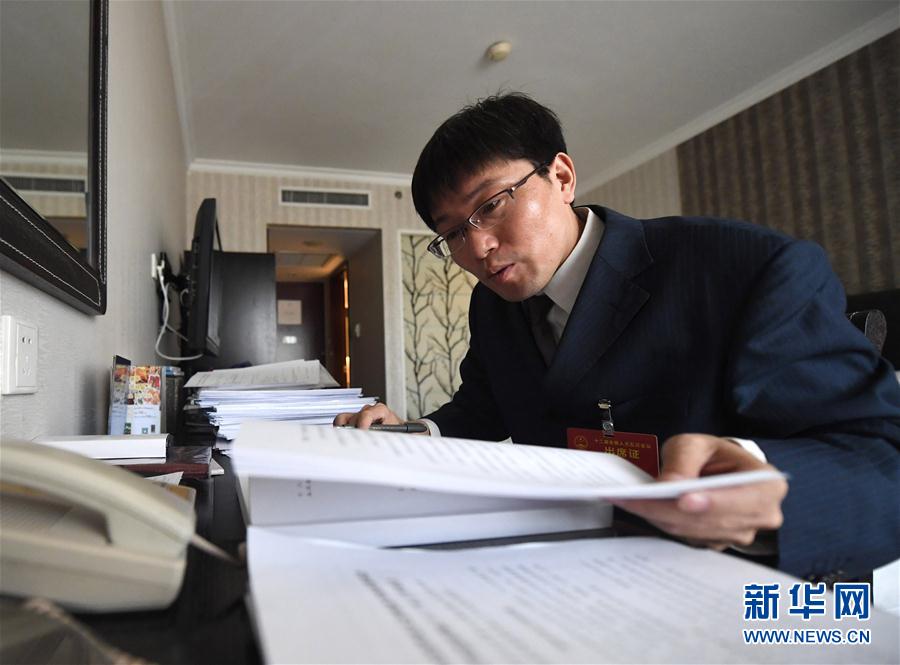 　　这是3月10日，王尚典在驻地房间整理文件。 新华社记者 杨青 摄