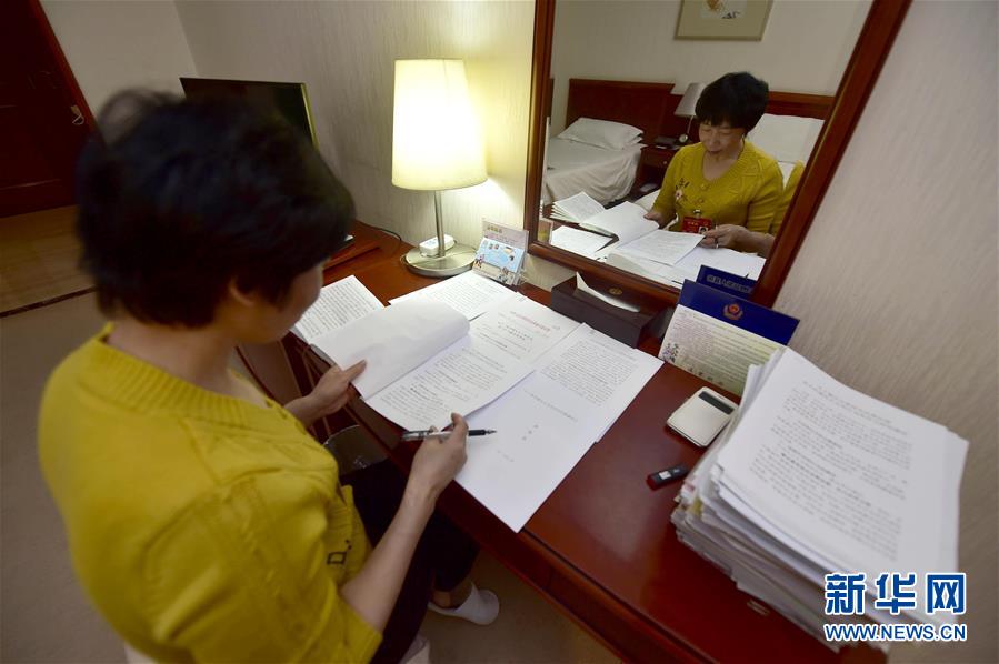 这是3月11日，薛海英在驻地房间整理自己的建议材料。 新华社记者岳月伟摄