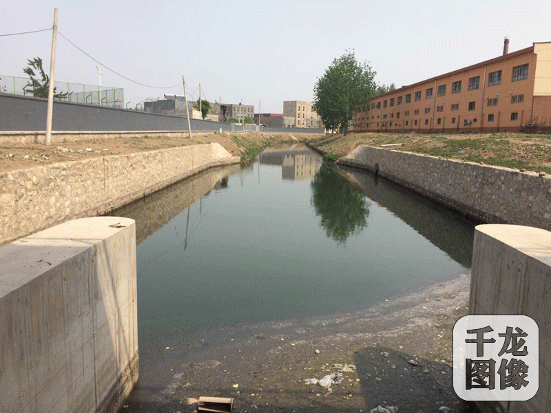 从北京通州区梨园南街开始，玉带河就成了一条明渠，2017年5月2日下午，记者现场目测玉带河的河水仍然是黑色的，这条河蜿蜒曲折流经华业东方玫瑰、金隅自由筑、花石匠、华远铭悦等社区。图为玉带河在梨园南街的起点。千龙网记者 于振华摄