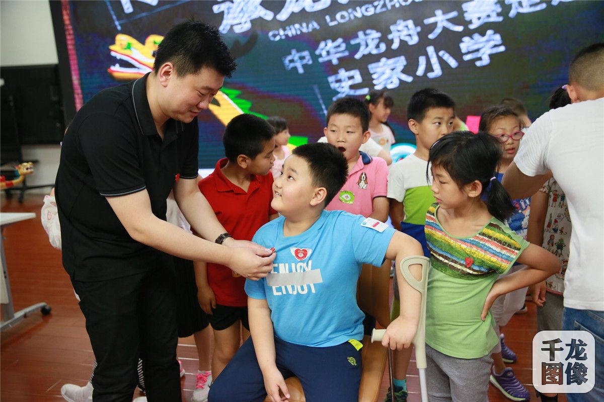 【16】中华龙舟大赛组委会代表吴鹏为孩子颁发大赛纪念徽章