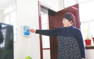 图为“煤改电”居民支淑梅向记者展示家中的室内温度。 《丰台报》供图