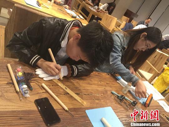 北京时装企业依文集团常设中国传统手工艺传习基地。图为中小学生在传习基地学传统手工艺制法。　陈建 摄