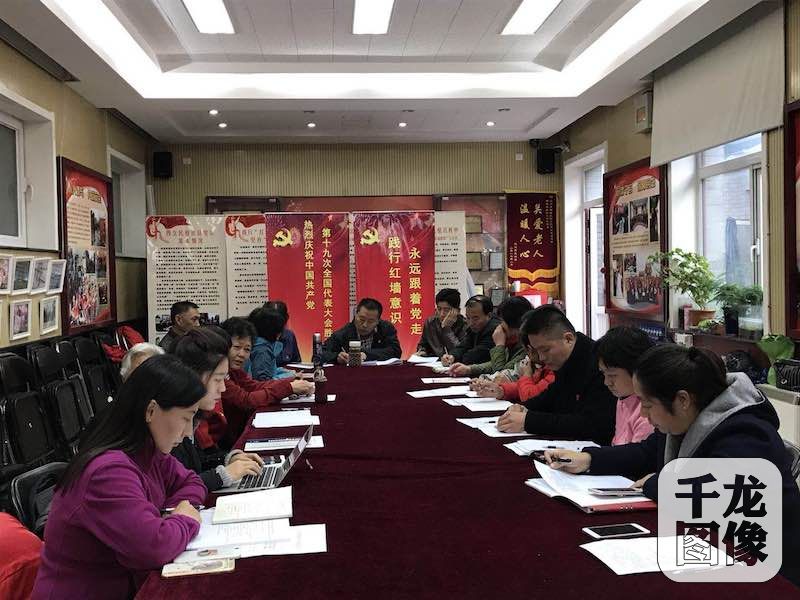 中国共产党第十九次全国代表大会10月18日在人民大会堂隆重开幕。图为在西城区西交民巷社区居委会内，22名社区党员、辖区单位党员以及社区干部群众，齐坐在电视机前，认真收看学习记录习总书记的大会报告，千龙网记者（左二）与党员干部群众一起学习十九大报告。西交民巷社区供图 千龙网发