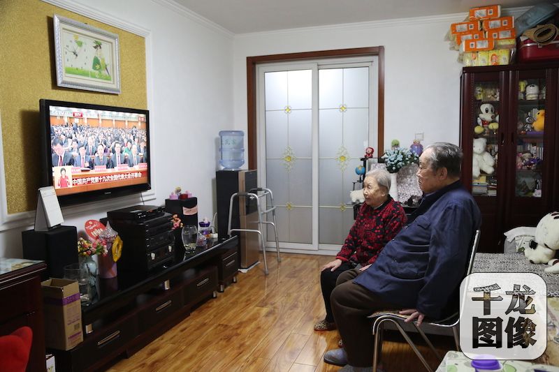 18日上午，党的十九大在人民大会堂开幕，丰台大瓦窑村全村党员、村民积极收看这一盛会。图为大瓦窑村老党员段德祥和老伴收看开幕会。丰台卢沟桥乡供图 千龙网发