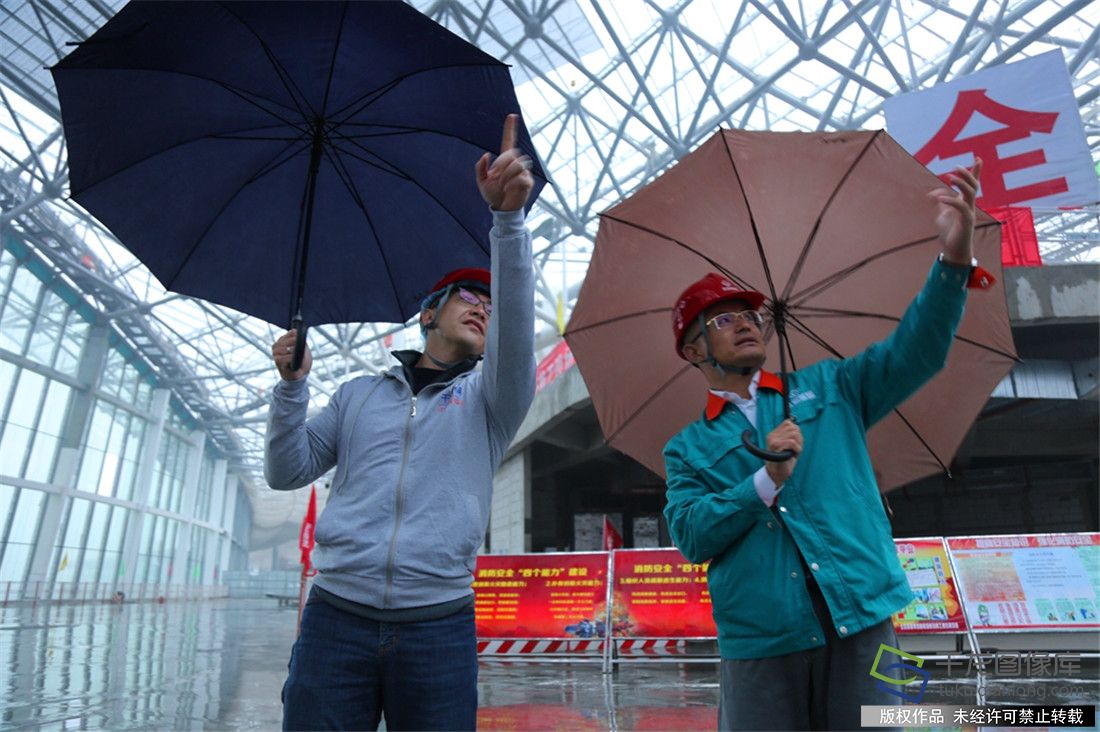 北京城建集团新机场航站楼工程项目经理李建华（左）向记者介绍新机场建设情况。