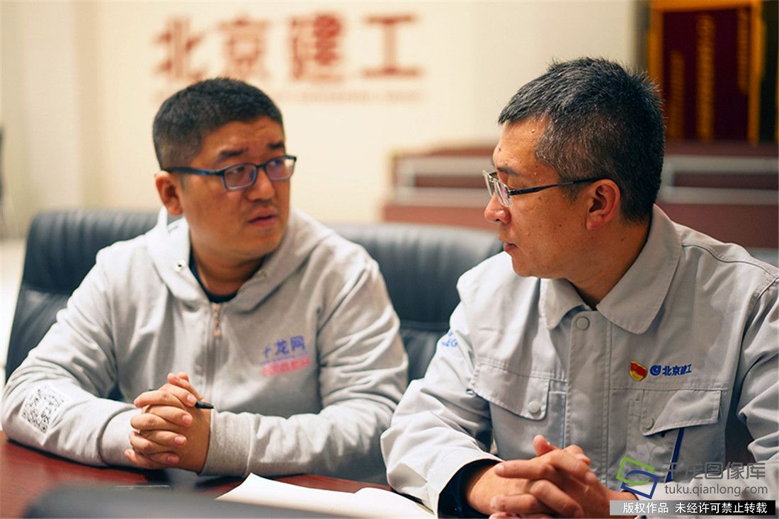 记者正在与北京建工集团北京新机场项目总承包部党总支书记曹常海交流学习心得体会
