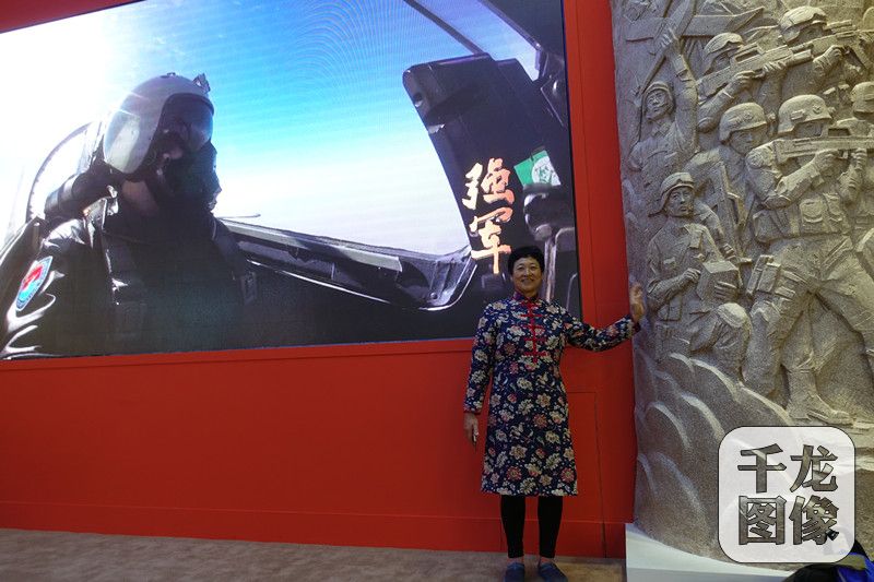 近日，&ldquo;砥砺奋进的五年&rdquo;大型成就展在北京展览馆开幕，在&ldquo;绿水青山就是金山银山 迈入社会主义生态文明新阶段&rdquo;展区。图为来自东北的李春霞与展厅大屏幕合影。千龙网记者 王大治摄
