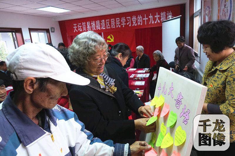 10月27日，腾退后的天坛简易楼老住户代表回到天坛街道睦邻驿站学习十九大精神。图为老住户贴上自己的十九大寄语。千龙网记者欧阳晓娟 摄