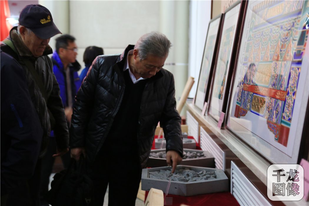 图为故宫博物院专家对参赛作品进行指导3