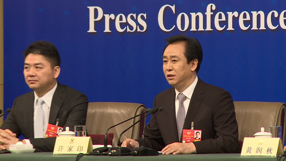 全国政协委员、恒大集团董事局主席许家印回答记者提问（右一）