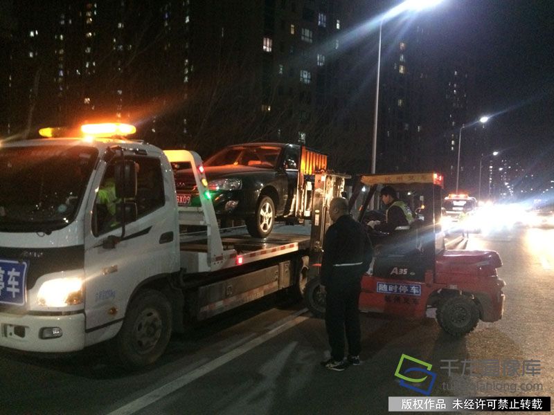 3月19日晚上7点半，北京通州交通支队出动两台道路清障车、一台叉车赶到梨园路，进行清障执法行动，引得大量群众围观和拍手叫好。图为通州交警支队的叉车正在清理违法停车作业。千龙网记者 于振华摄