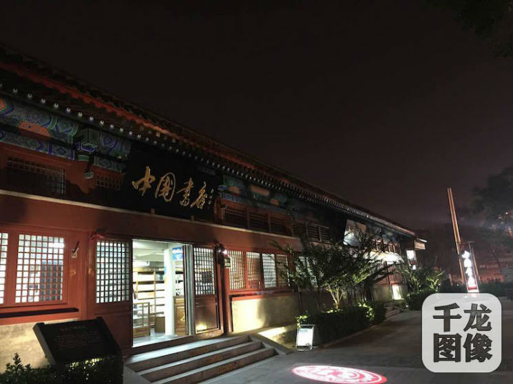 北京城中轴线上,地安门东大街与西大街的交汇处,矗立着一栋古建筑:红外墙配蓝绿色门梁,黄琉璃瓦覆顶,远观形似雁翅,得名雁翅楼。图为雁翅楼中国书店。千龙网记者 薄晨棣摄